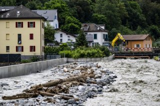 A Chippis, une pelleteuse enlève des pierres dans le lit de la Navizence, qui se jette dans le Rhône, au lendemain des intempéries